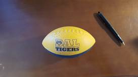Dal Tigers football on table with a pen.